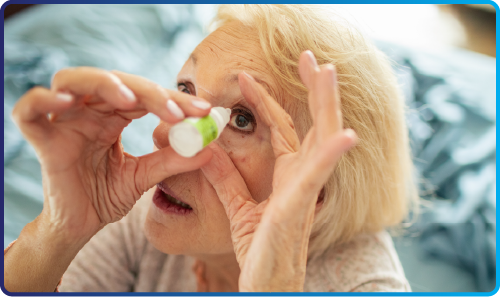 Elderly woman using eye drops